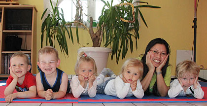 Gruppenfoto Jannette Haas aus Rösrath mit ihren Tageskindern. Alle liegen auf dem Bauch und haben die Köpfe auf die Hände gestützt.